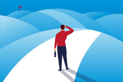Businessman standing in the mountains watching the distance